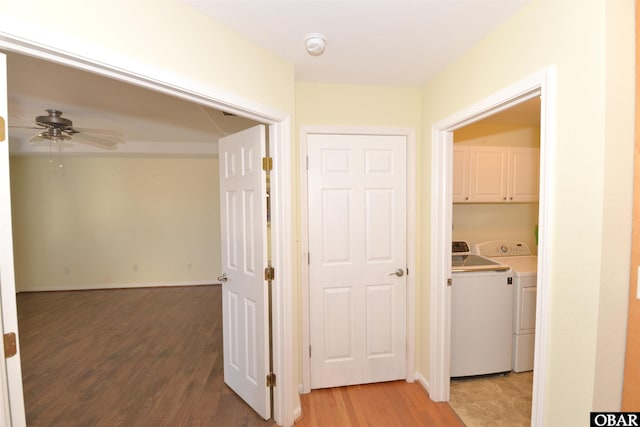 corridor with washer and clothes dryer, light wood-style flooring, and baseboards