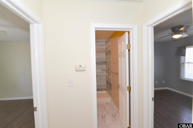 hall with wood finished floors and baseboards