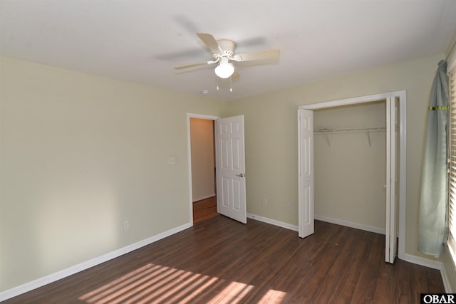 unfurnished bedroom with dark wood-style flooring, a closet, a ceiling fan, and baseboards