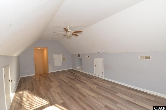 bonus room featuring visible vents, vaulted ceiling, light wood-style flooring, and baseboards