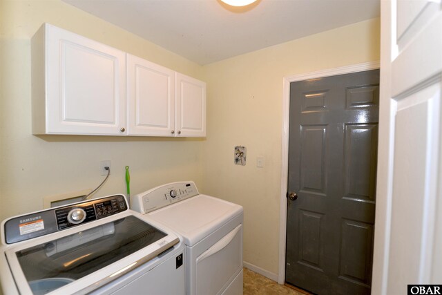 clothes washing area featuring cabinet space, baseboards, and separate washer and dryer