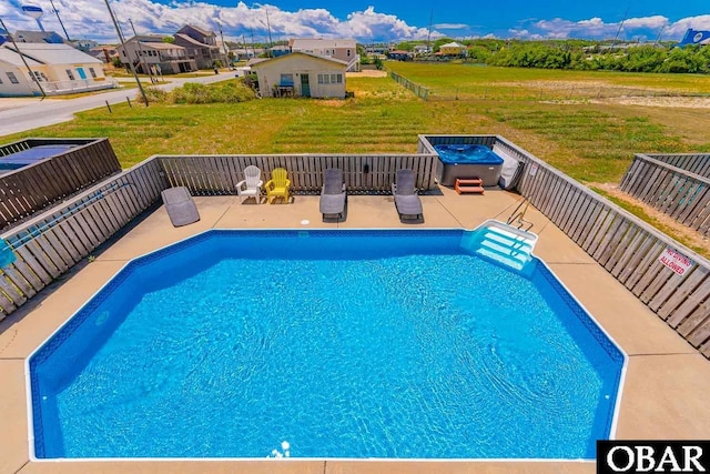 view of pool featuring a fenced in pool, a residential view, a patio area, and a lawn