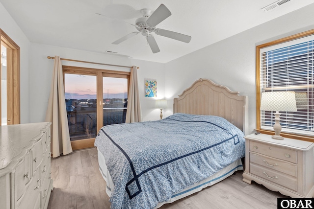 bedroom featuring light wood-style floors, visible vents, and multiple windows