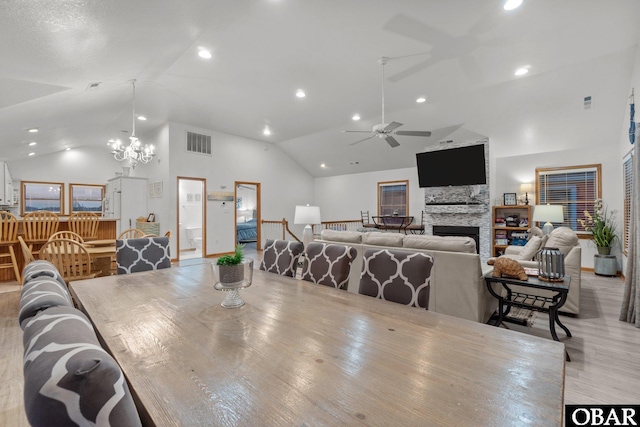 dining area with recessed lighting, visible vents, a fireplace, high vaulted ceiling, and ceiling fan with notable chandelier