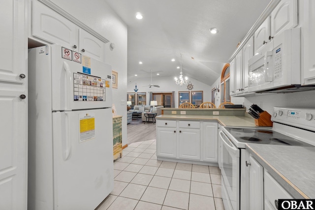 kitchen with white appliances, a peninsula, vaulted ceiling, white cabinetry, and light tile patterned flooring