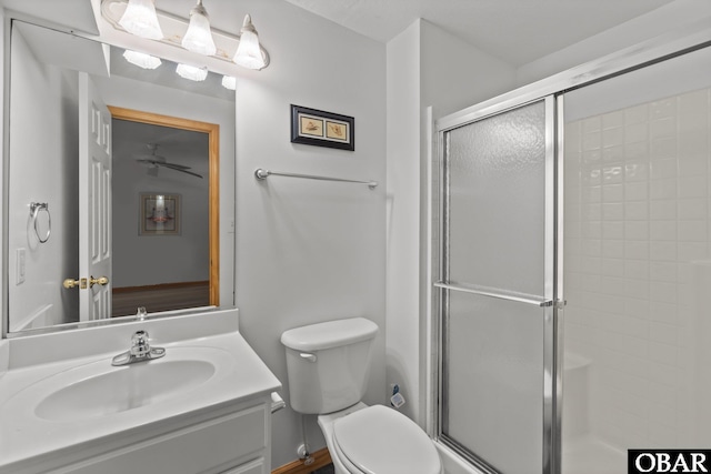 full bathroom featuring a stall shower, vanity, and toilet