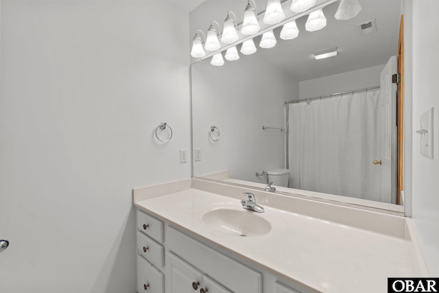 full bath featuring toilet, vanity, and visible vents