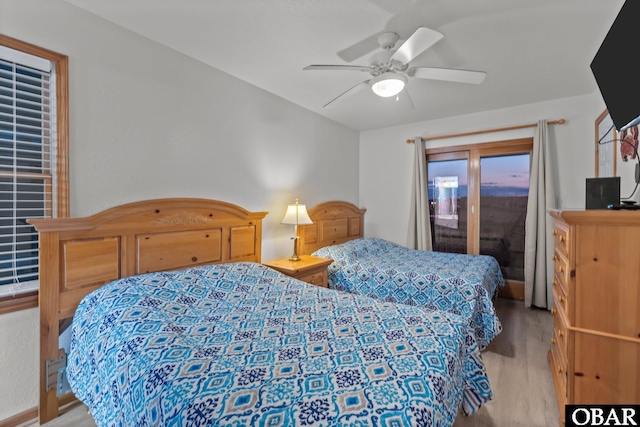 bedroom featuring access to exterior, light wood-style flooring, and a ceiling fan