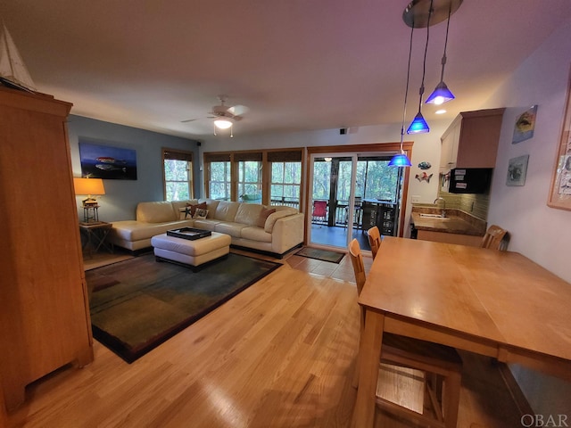 living room featuring light wood finished floors, a wealth of natural light, and a ceiling fan