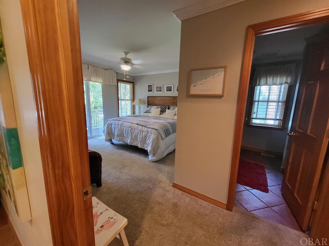 bedroom with ornamental molding, light carpet, baseboards, and light tile patterned flooring