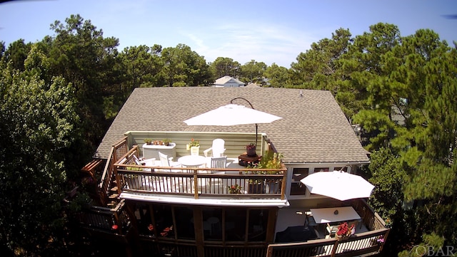 back of property with roof with shingles