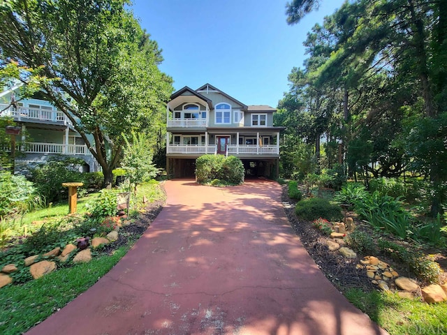 view of front of house featuring driveway, a carport, and a balcony