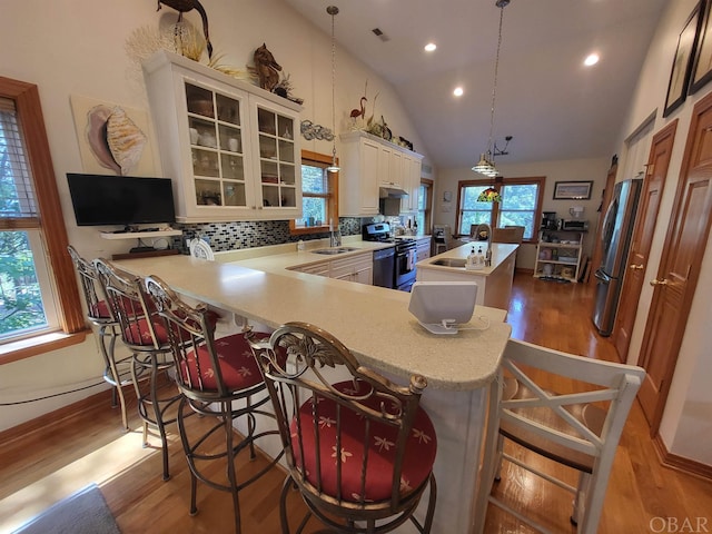 kitchen featuring light countertops, a center island, glass insert cabinets, and decorative light fixtures