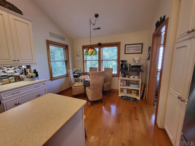 interior space with lofted ceiling, light wood finished floors, and visible vents