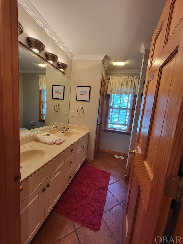 full bath featuring double vanity, visible vents, ornamental molding, and a sink