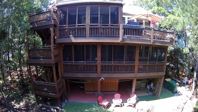 rear view of property with a sunroom and a patio