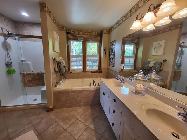 full bathroom with a bath, a shower stall, double vanity, and a sink