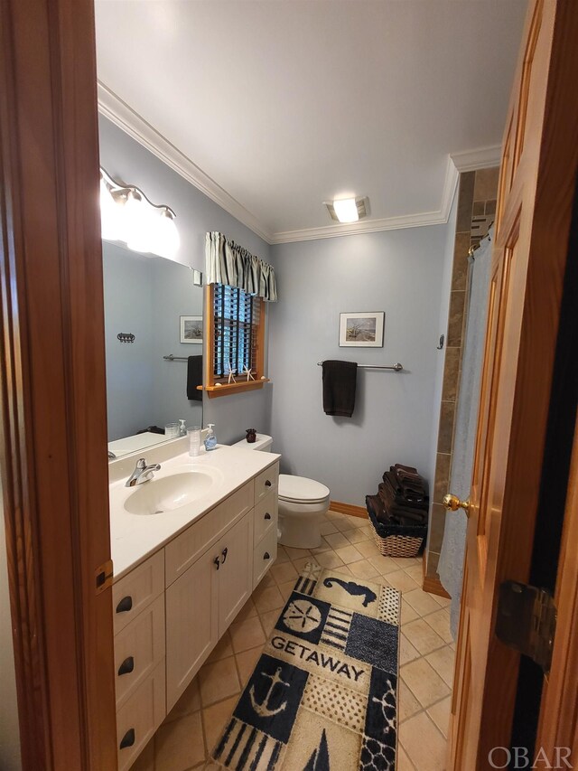 bathroom with baseboards, toilet, tile patterned flooring, crown molding, and vanity