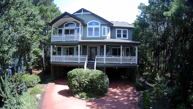 view of front facade with a carport, a porch, and a balcony