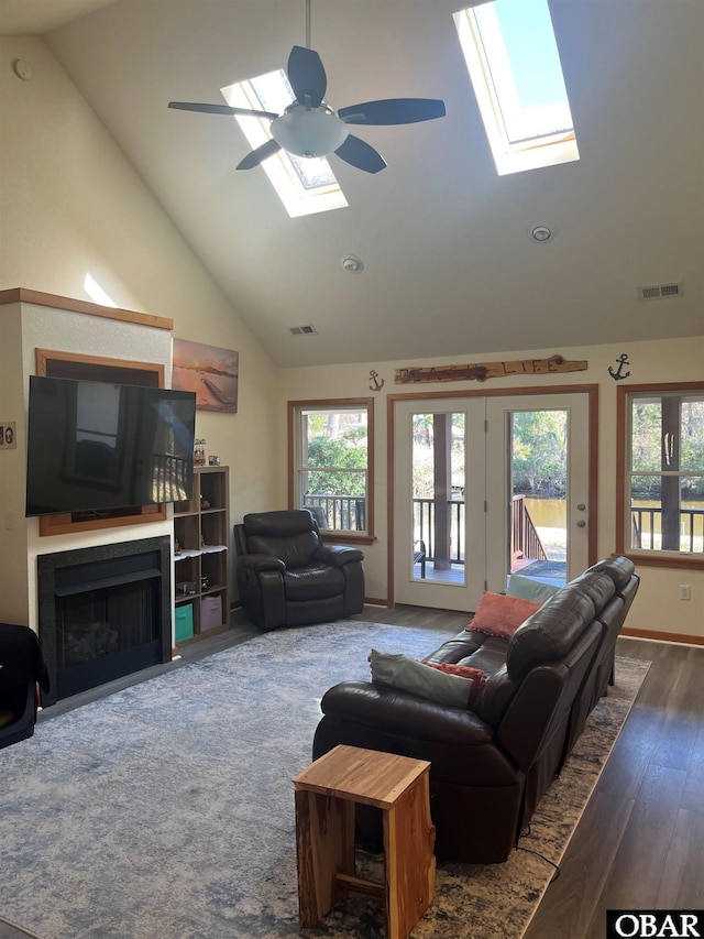 living room with a healthy amount of sunlight, a skylight, and visible vents