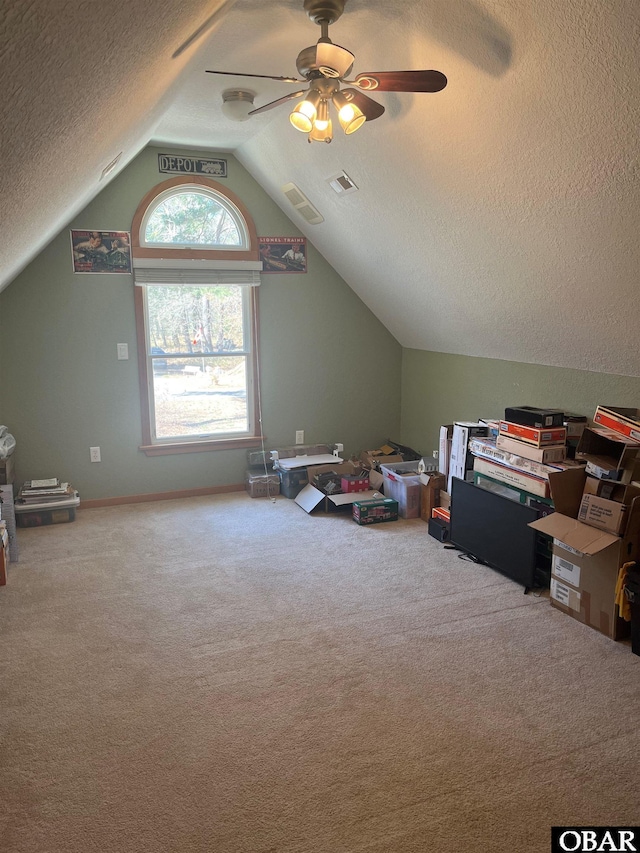 additional living space featuring a textured ceiling, visible vents, vaulted ceiling, and carpet flooring