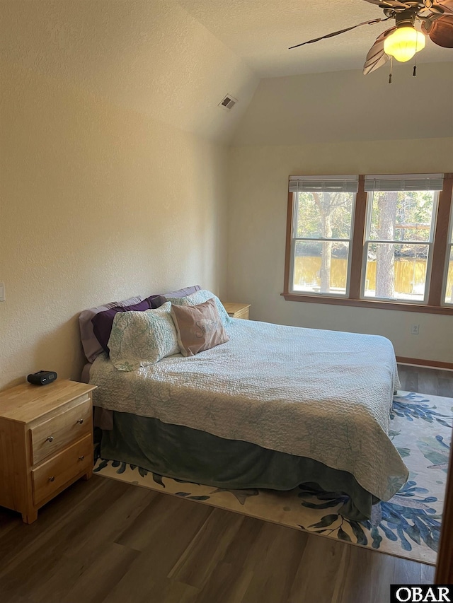 bedroom featuring lofted ceiling, a ceiling fan, visible vents, and wood finished floors