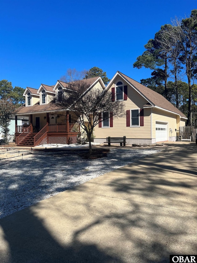 view of front of home with covered porch, fence, and an attached garage