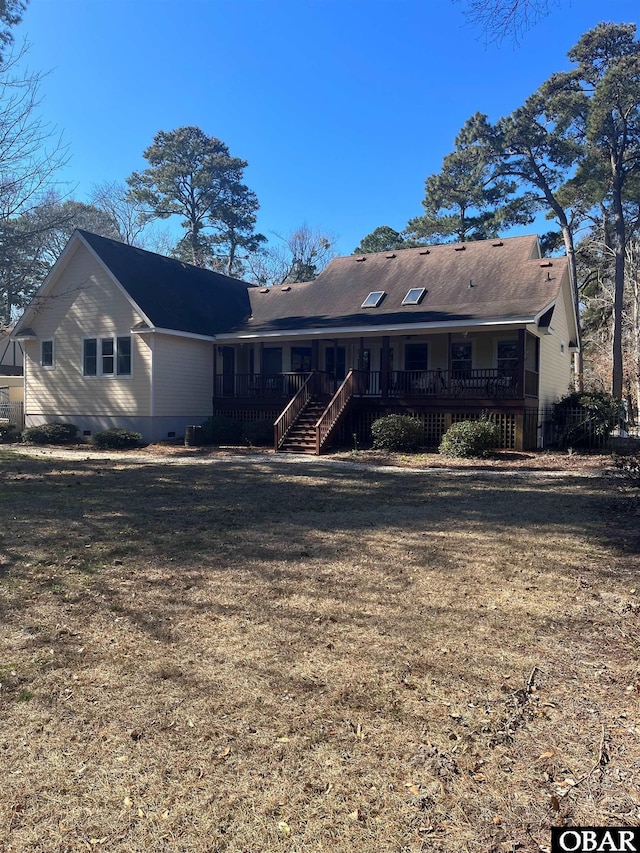 rear view of house with crawl space, stairs, a deck, and a lawn