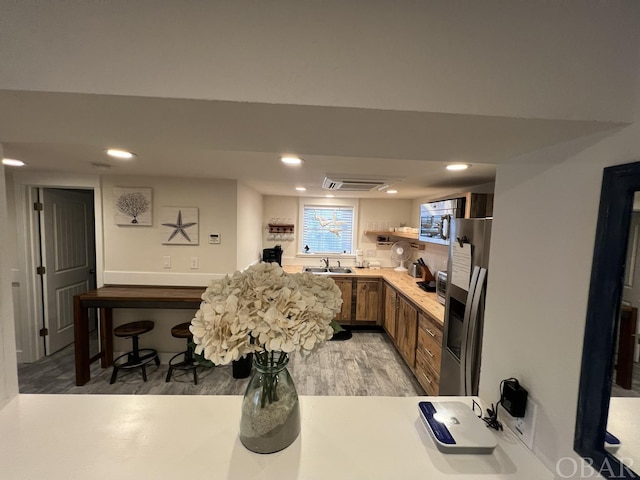 kitchen with brown cabinetry, stainless steel appliances, light countertops, and recessed lighting