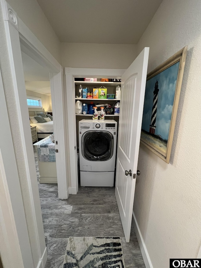 laundry area featuring washer / dryer, baseboards, laundry area, and dark wood finished floors