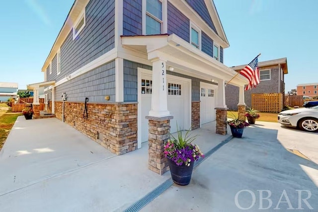 exterior space featuring stone siding and concrete driveway