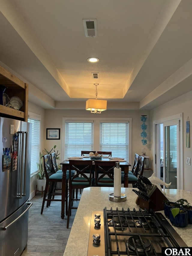 kitchen featuring light countertops, high end fridge, and a raised ceiling