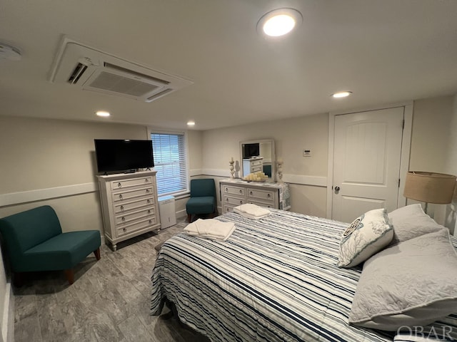 bedroom with light wood-type flooring, a closet, and recessed lighting