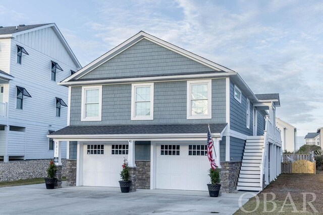 view of front of house featuring driveway, stone siding, and a garage