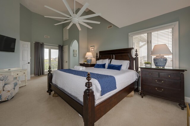 bedroom with arched walkways, high vaulted ceiling, light colored carpet, visible vents, and a ceiling fan