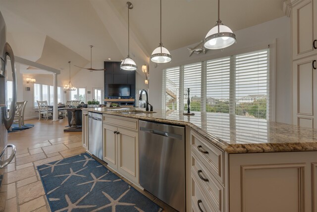 kitchen with stone tile floors, a sink, open floor plan, stainless steel dishwasher, and an island with sink