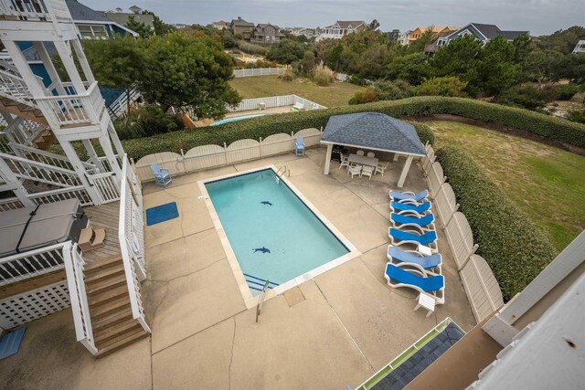 community pool with stairs, a patio, a bar, and fence