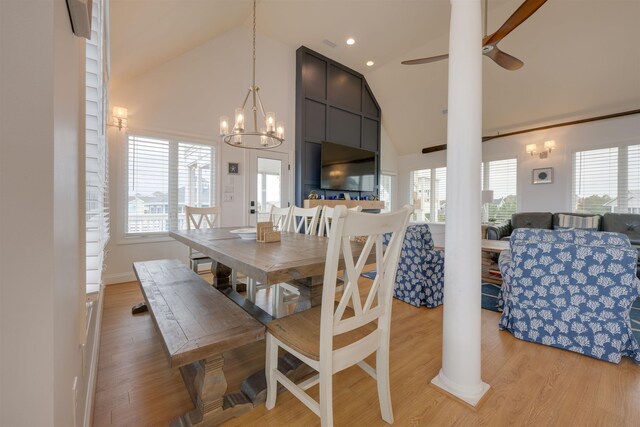 dining space featuring high vaulted ceiling, light wood-type flooring, and a healthy amount of sunlight