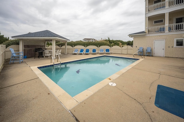 view of swimming pool with a fenced backyard, a fenced in pool, and a gazebo