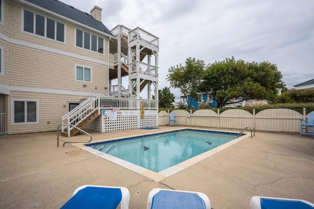 view of pool featuring stairway, a patio area, fence, and a fenced in pool