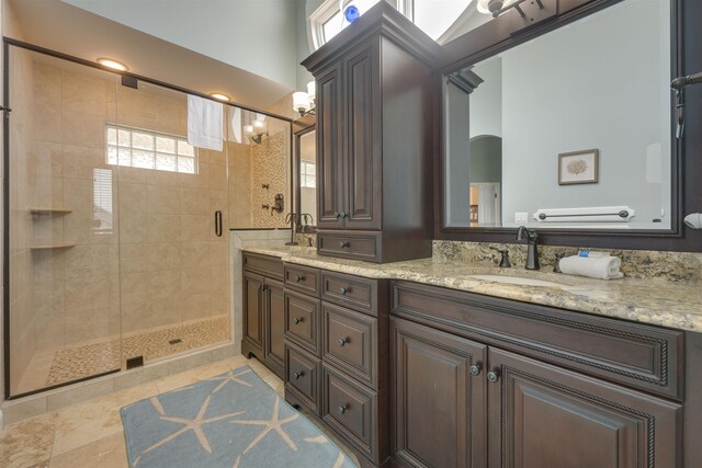 full bathroom featuring tile patterned flooring, a sink, a shower stall, and double vanity