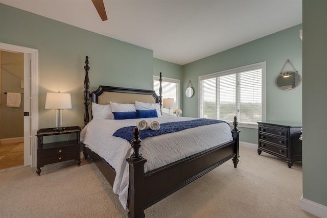 bedroom with ceiling fan, baseboards, and light colored carpet