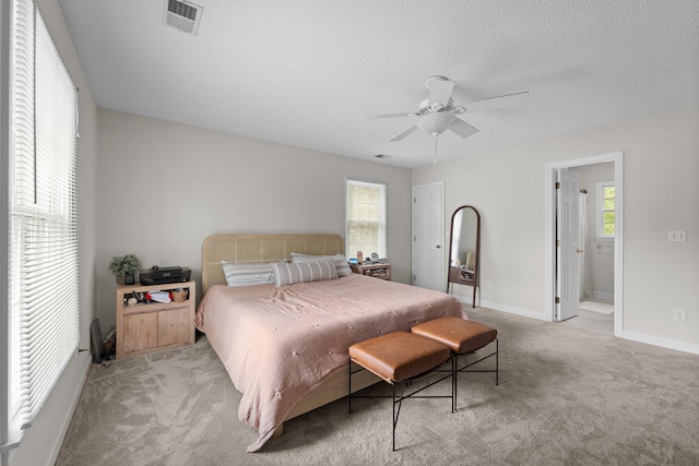 bedroom with light colored carpet, visible vents, a ceiling fan, a textured ceiling, and baseboards