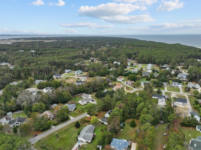 birds eye view of property featuring a forest view and a water view