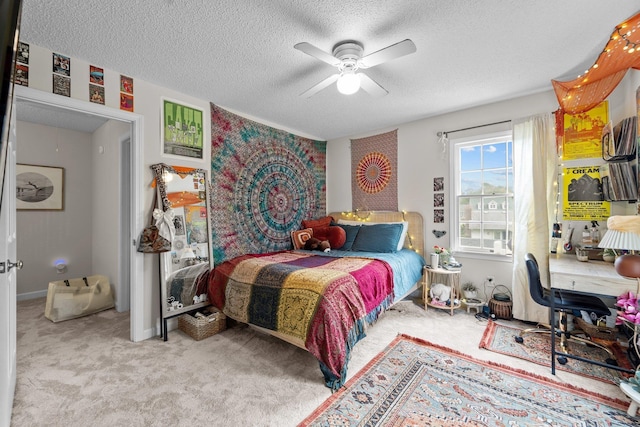 carpeted bedroom featuring a ceiling fan and a textured ceiling