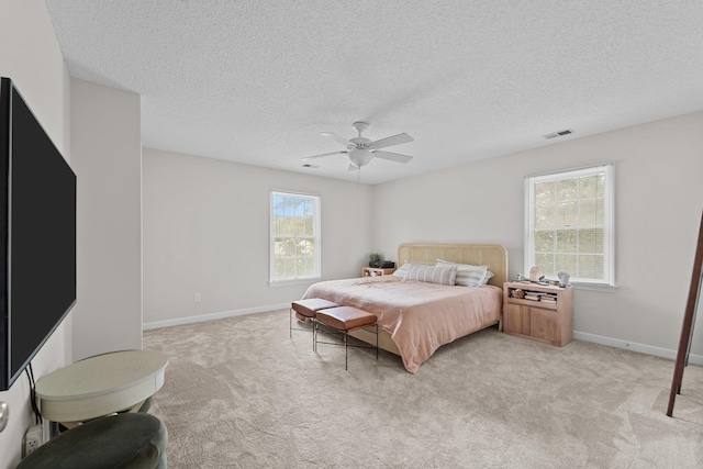 bedroom featuring a ceiling fan, light colored carpet, visible vents, and baseboards