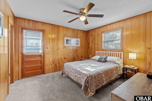 bedroom featuring ceiling fan, carpet flooring, and a textured ceiling