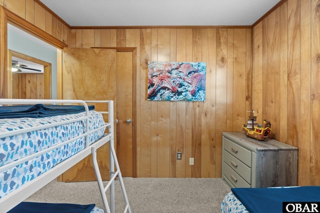 bedroom featuring carpet flooring, wood walls, and ornamental molding