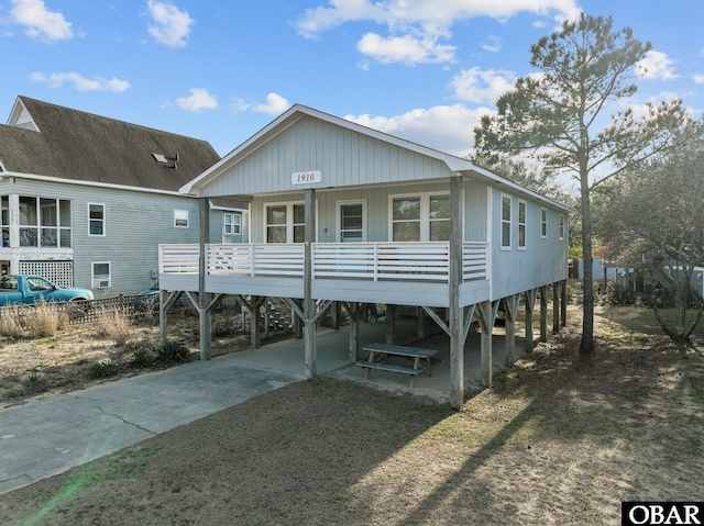 view of front of property with a carport, a porch, driveway, and a shingled roof