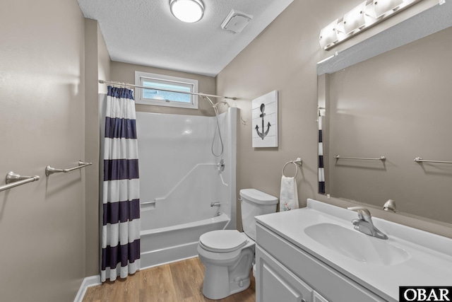 bathroom with shower / bath combo with shower curtain, toilet, a textured ceiling, wood finished floors, and vanity